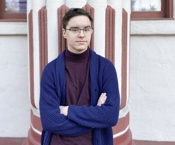 A college student standing by a building